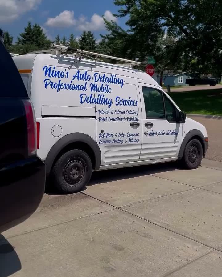 Black Tahoe on a driveway with Nino's lettered mobile detailing van parked behind it